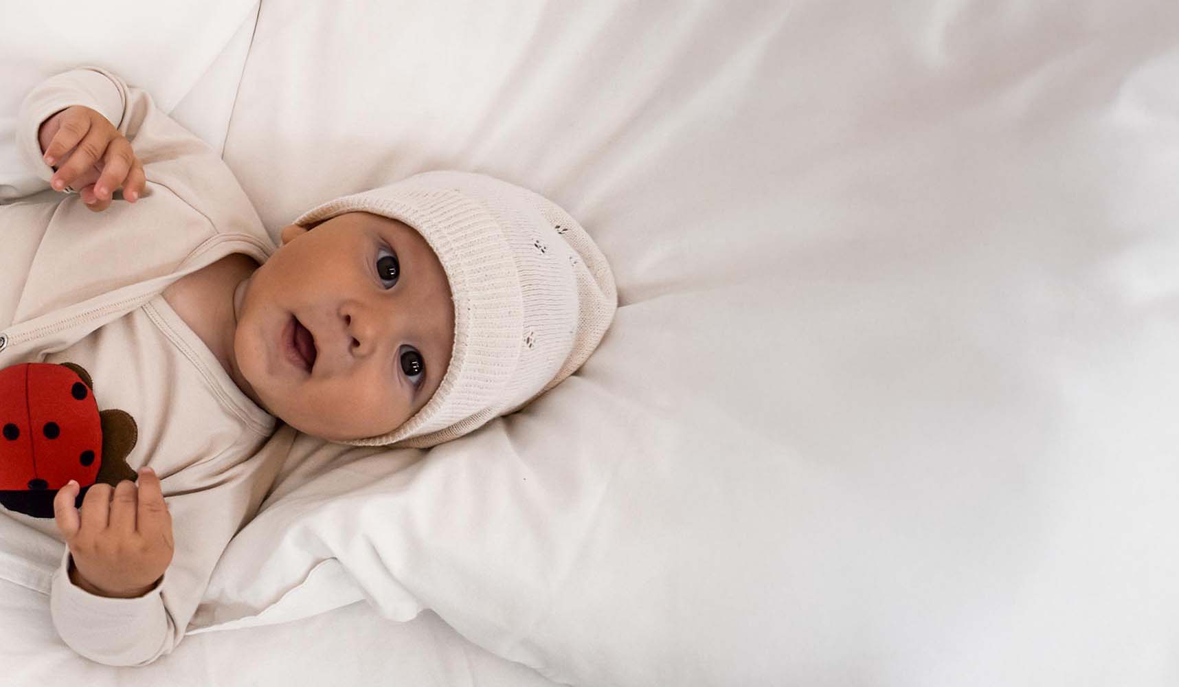 Baby liegt auf Bett mit MARY