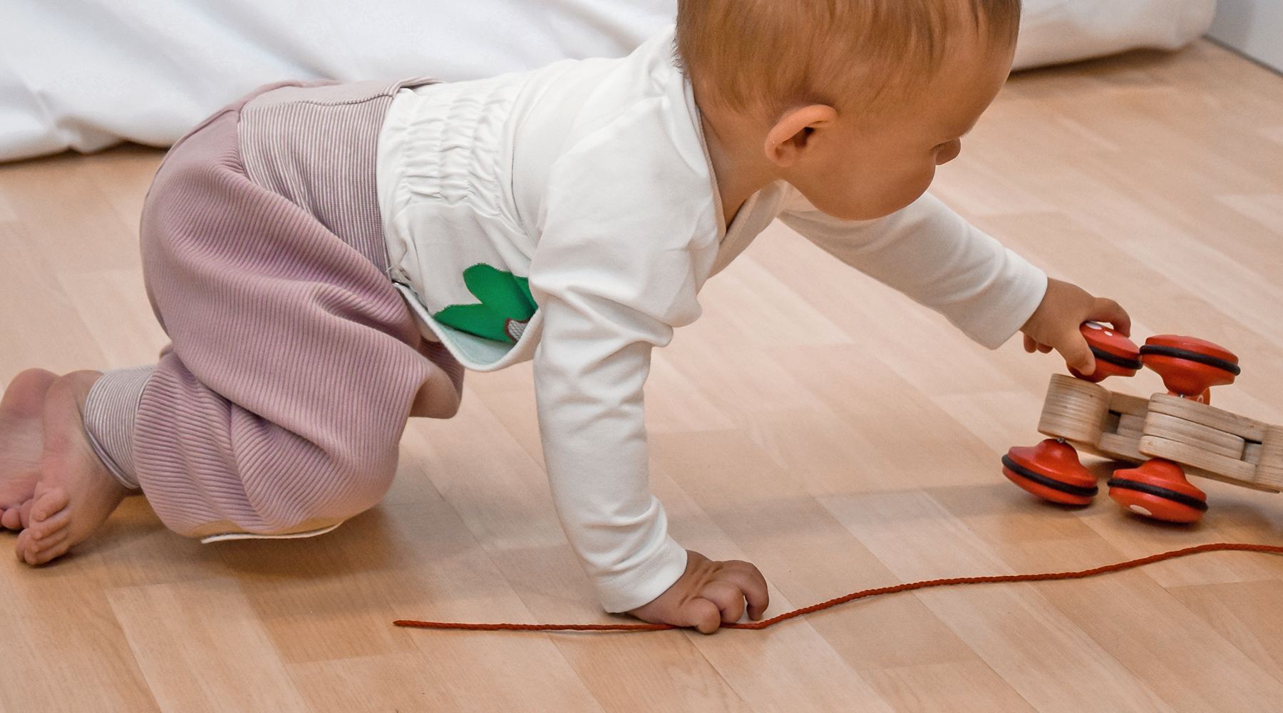 Baby krabbelt auf allen Vieren und trainiert Motorik und Gleichgewicht