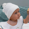 Weiße Baby-Strickmütze mit Bommel – weich, wärmend & süßes Accessoire